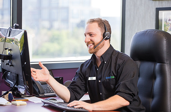 Photo of a guard.me employee wearing a headset speaking to a client